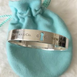 Tiffany & Co. Diamond Keyhole Bangle.Featuring 2 .003 carat diamonds.
